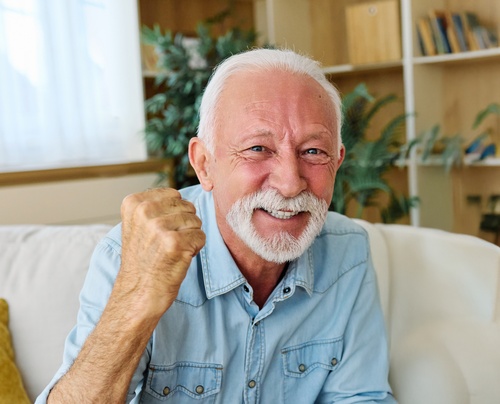 Smiling senior man with a confident, healthy smile relaxing at home